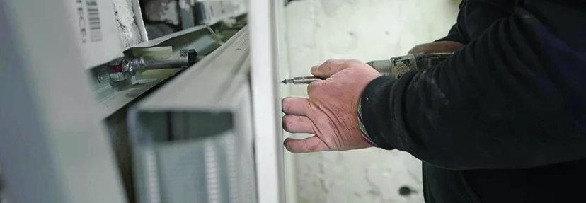 Person befestigt Metallrahmen an Wand